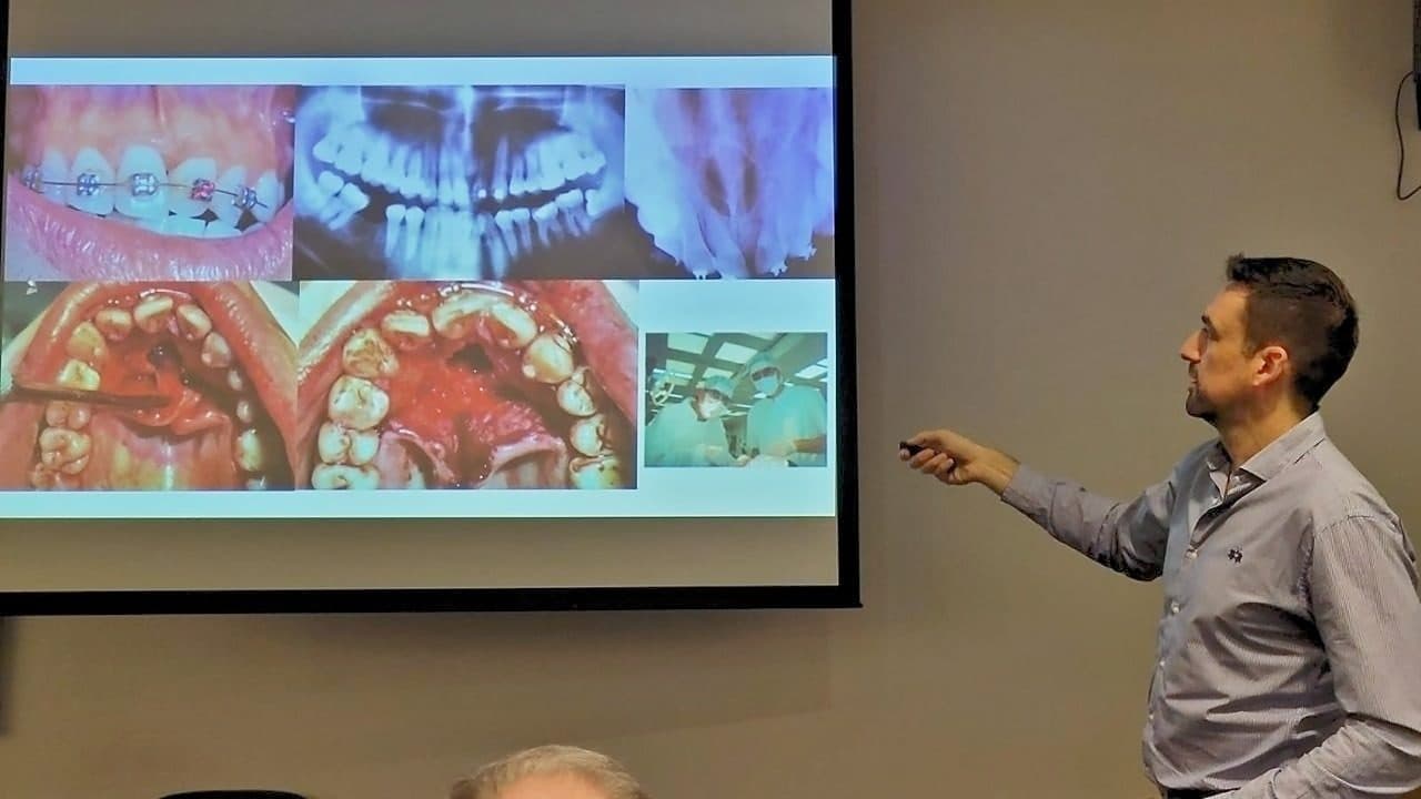 Hernán Bilczyk explicando casos clínicos proyectados en un curso