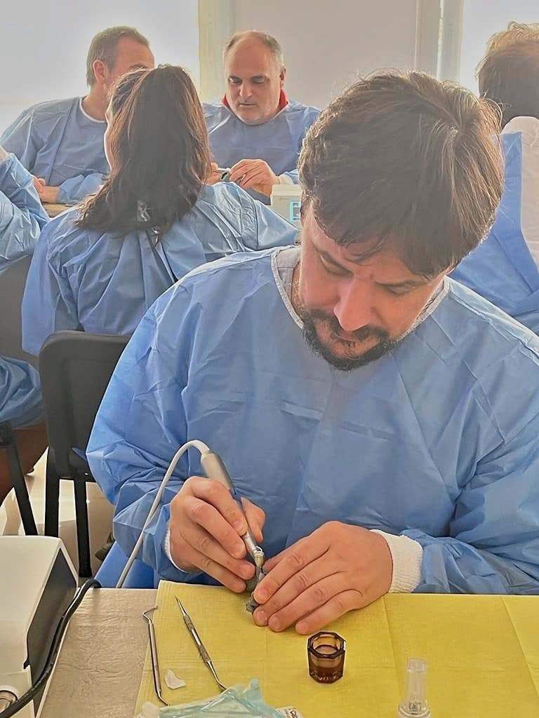 Colega con camisolín trabajando en su puesto