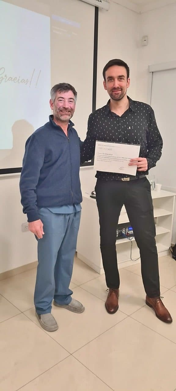 Hernán Bilczyk entregando un certificado a un colega